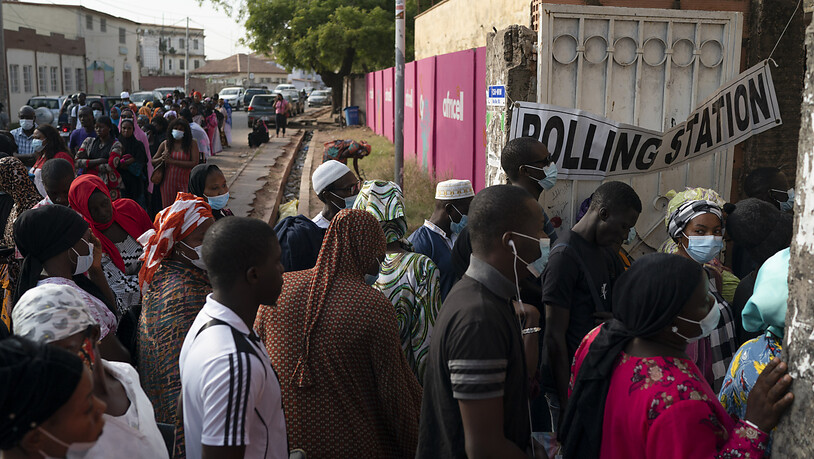 Menschen stehen vor einem Wahllokal in einer Schlange um ihre Stimme für die Parlaments- und Präsidentschaftswahlen abzugeben. Foto: Leo Correa/AP/dpa