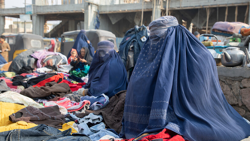 HANDOUT - Amena (M), frühere Rektorin einer Schule und Nazila (r), ehemalige Lehrerin, verkaufen auf einem Markt in Mazar-i-Sharif Kleider, weil beide ihre Arbeit verloren haben. Foto: Julian Frank/WFP/dpa