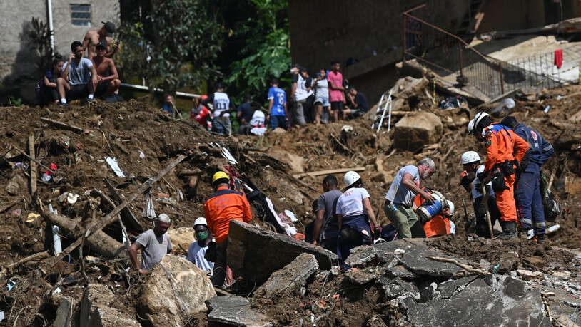 Rettungskräfte und Anwohner suchen nach Opfern in einem von Erdrutschen betroffenen Gebiet in Petropolis. Foto: Andre Borges/dpa