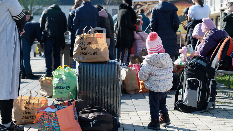 Geflüchtete aus der Ukraine stehen mit ihrem Gepäck vor den Gebäuden eines Flüchtlingsheims in Köln Worringen. Foto: Henning Kaiser/dpa