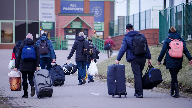 Einige Menschen passieren am Abend die ukrainsch-polnische Grenze in Medyka in Richtung Ukraine. Die Zahl der Flüchtlinge aus der Ukraine beläuft sich nach Angaben eines Sprechers der UN-Organisation für Migration (IOM) inzwischen auf 1,25 Millionen…
