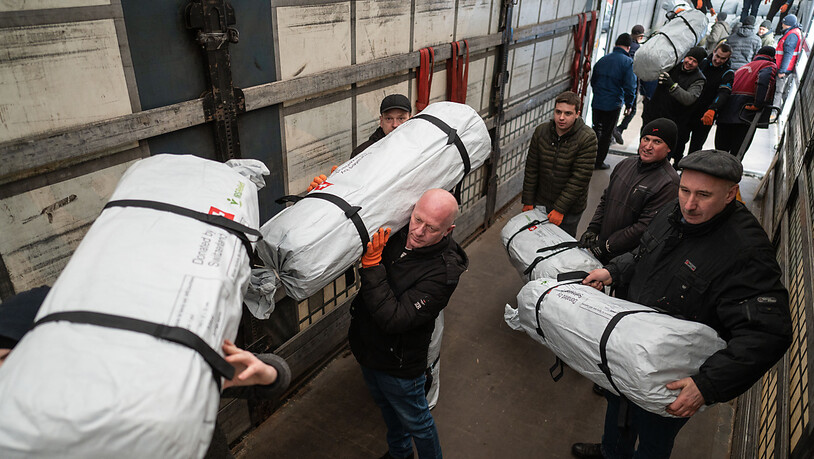 Mitglieder des Schweizerisches Korps für Humanitäre Hilfe (SKH) und Caritas Ukraine laden Schweizer Hilfsgüter beim polnisch-ukrainischen Grenzübergang Hrebenne/Rawa-Ruska auf ukrainische Lastwagen um. (Aufnahme vom 3. März 2022)