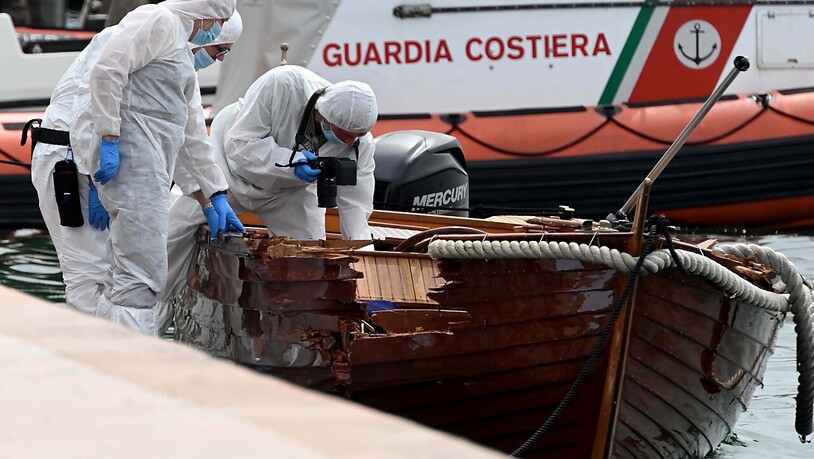 ARCHIV - Forensiker begutachten die Schäden an dem verunglücktem Boot im Hafen von Salo. Foto: Gabriele Strada/AP/dpa