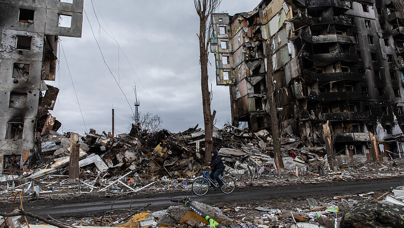 Ein Mann fährt auf einem Fahrrad an einem zerstörten Wohnhaus in der Stadt Borodjanka vorbei. Der ukrainische Innenminister Denys Monastyrskyj hat ukrainische Medien am Donnerstagmorgen von großen Zerstörungen in der Kleinstadt Borodjanka bei Kiew…