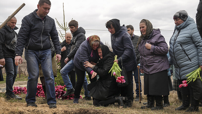 Liudmila Sumanschuk (Mitte, schwarzer Mantel), die Großmutter von Veronika Kuts, weint während ihrer Beerdigungszeremonie im Dorf L'giw. Veronika Kuts war 12 Jahre alt und wurde während eines russischen Bombardements getötet. Foto: Evgeniy Maloletka/AP…