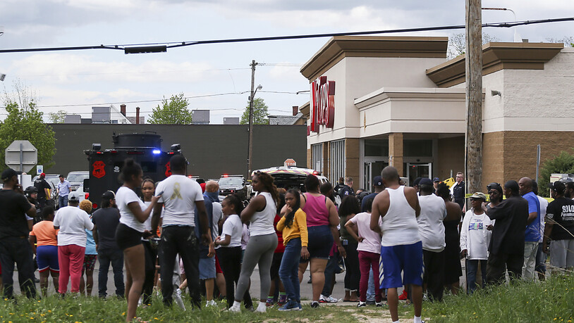 Eine Menschenmenge versammelt sich, während die Polizei nach Schüssen in einem Supermarkt ermittelt. Foto: Joshua Bessex/AP/dpa
