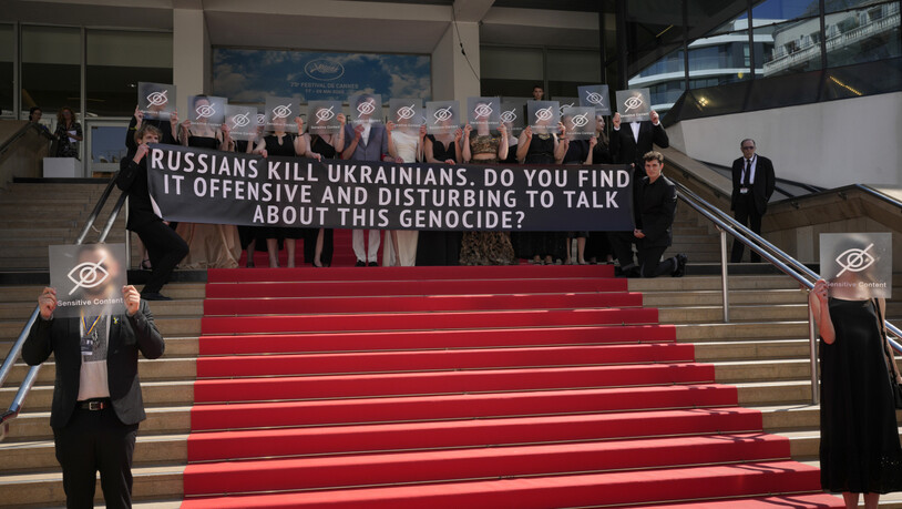 Filmemacher des Films "Butterfly Vision" und Festivalbesucher nehmen an einer Demonstration teil und halten ein Transparent mit der Aufschrift "Russen töten Ukrainer". Finden Sie es anstößig oder beunruhigend, über diesen Völkermord zu sprechen?" Foto:…