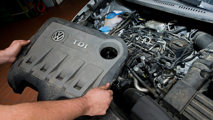 Die Abdeckung eines vom Abgas-Skandal betroffenen 2.0l TDI Dieselmotor vom Typ EA189 in einem VW Touran in einer Autowerkstatt in Hannover. (Archivbild)