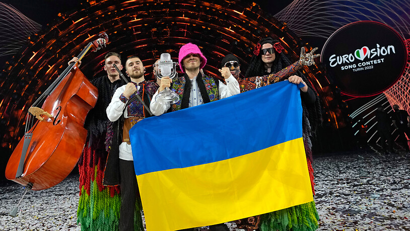 ARCHIV - Die Gruppe Kalush Orchestra aus der Ukraine jubelt über den Sieg des Eurovision Song Contest (ESC). Der nächste Eurovision Song Contest (ESC) findet wegen des russischen Angriffskriegs nicht beim diesjährigen Sieger Ukraine statt. Das teilte die…