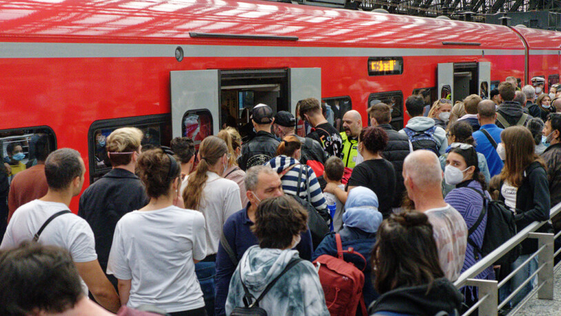 Reisende in Köln versuchen auf einem überfülltem Perron im Hauptbahnhof in einen Regionalzug zu steigen. (Archivbild)
