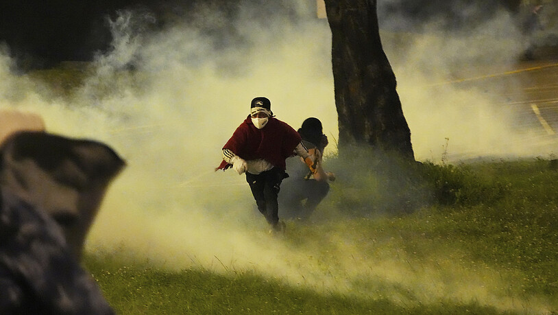 Indigene Demonstranten fliehen vor Tränengas, das von der Polizei eingesetzt wurde. Foto: Dolores Ochoa/AP/dpa