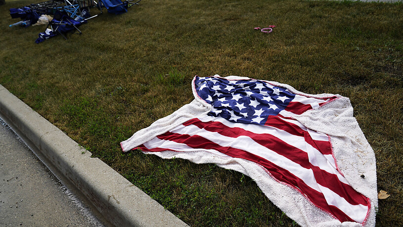 Leere Stühle und eine Decke mit amerikanischer Flagge liegen auf dem Boden, nachdem ein Schütze bei einer Parade anlässlich des Nationalfeiertags in den USA das Feuer eröffnet hatte. Foto: Nam Y. Huh/AP/dpa