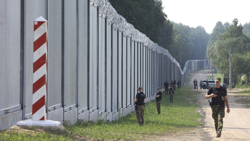 Polnische Grenzschützer patrouillieren im Bereich eines neu errichteten Grenzzauns zwischen Polen und Belarus. Foto: Michal Dyjuk/AP/dpa