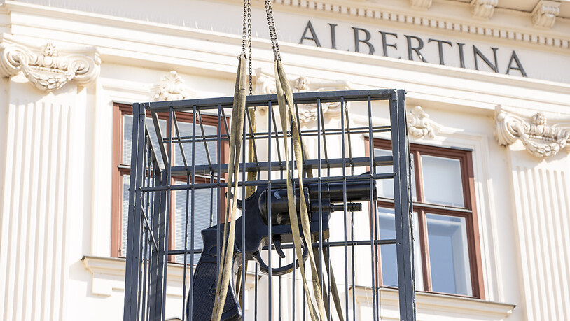"Imagine" heißt der Riesen-Revolver in einem Käfig des Künstlers Vladimir Dodig Trokut, der zur Installation mit einem Kran auf das Flugdach der Albertina gezogen wird. Das Kunstobjekt sei als Botschaft des Friedens zu verstehen. Foto: Tobias Steinmaurer…