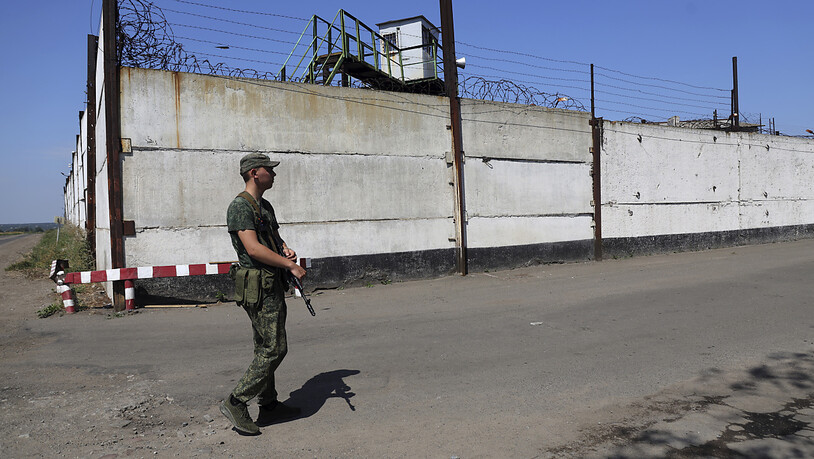 Ein Soldat steht Wache neben der Mauer eines Gefängnisses in Oleniwka, in einem von den von Russland unterstützten Separatisten kontrollierten Gebiet. Foto: -/AP/dpa
