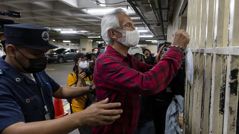 Jose Ruben Zamora, Chefredakteur der Zeitung «El Periodico», wird von einem Polizisten abgetastet, bevor er nach einer Gerichtsverhandlung wieder in eine Zelle gebracht wird. Foto: Moises Castillo/AP/dpa