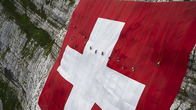 Die 80 mal 80 Meter grosse Schweizerfahne hängt an einer Felswand unterhalb des Säntis in der Ostschweiz.