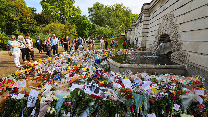 Zahlreiche Blumen und Trauerbekundungen liegen an einem Brunnen im St. James's Park nahe dem Buckingham-Palast. Die britische Königin Elizabeth II. ist am 08.09.2022 im Alter von 96 Jahren gestorben. Foto: Christian Charisius/dpa
