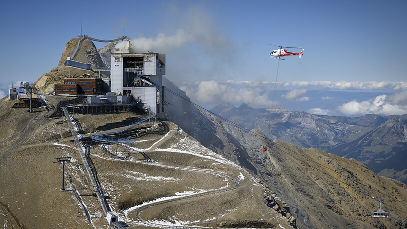 Ein Helikopter fliegt Löschwasser zur Bergstation von Glacier 3000.
