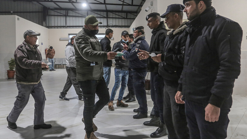 ARCHIV - Polizisten (r) kontrollieren die Papiere von palästinensischen Arbeitern am Erez-Übergang, die Beit Hanoun im nördlichen Gazastreifen verlassen, um in Israel zu arbeiten. Foto: Mohammed Talatene/dpa