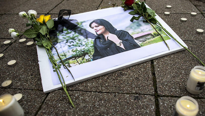 Ein Bild der verstorbenen Iranerin Mahsa Amini, die in der vergangenen Woche im Iran nach ihrer Verhaftung durch die Sittenpolizei gestorben war, ist während einer Solidaritätskundgebung an der Marktkirche zu sehen. Foto: Christoph Reichwein/dpa -…