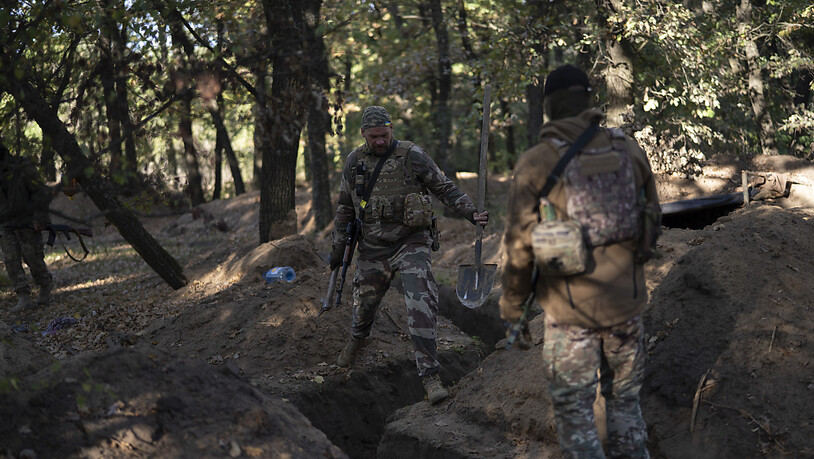Ukrainische Soldaten überprüfen die von russischen Soldaten ausgehobenen Schützengräben. Foto: Leo Correa/AP/dpa