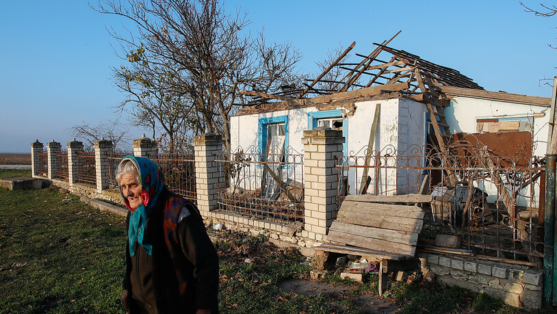 Eine ältere ukrainische Frau sammelt humanitäre Hilfsgüter vor ihrem Haus in einem Dorf, das durch militärische Auseinandersetzungen stark beschädigt wurde. Nach dem russischen Abzug rücken die Ukrainer weiter auf die Gebietshauptstadt Cherson im Süden…