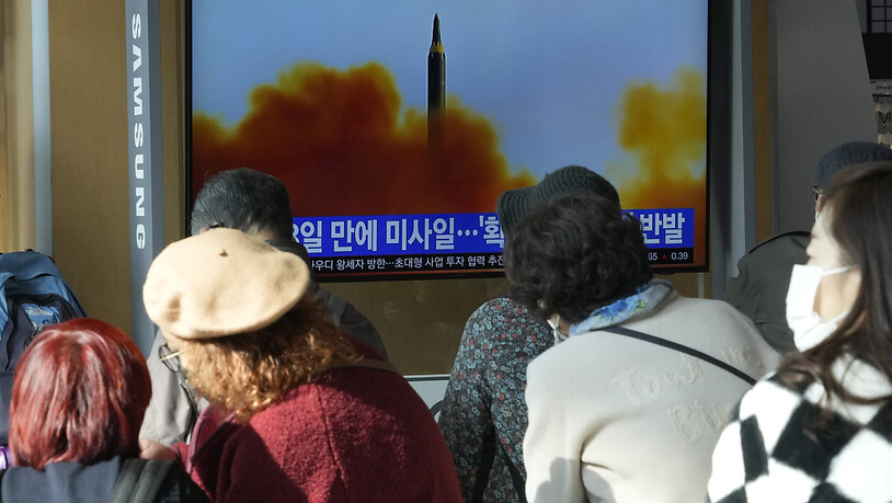 Menschen sitzen nahe eines Monitors auf dem eine Nachrichtensendung mit einem Archivbild über den neusten Raketentest Nordkoreas berichtet. Foto: Ahn Young-Joon/AP/dpa