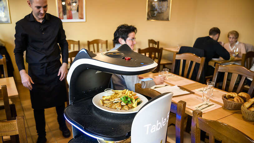 Der Roboter schlängelt sich zwischen den Tischen hindurch und bringt in Lausanner Restaurant das Essen.