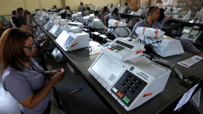 ARCHIV - Mitarbeiter des Wahlgerichts versiegeln die elektronischen Wahlmaschinen in Vorbereitung auf die Stichwahl in der zweiten Wahlrunde am 30. Oktober. Foto: Eraldo Peres/AP/dpa