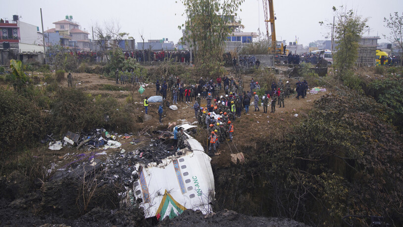 Nach dem Flugzeugabsturz in Nepal dursuchten Rettungskräfte das Wrack nach Überlebenden. Foto: Uncredited/AP/dpa