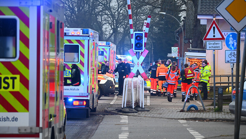 Einsatzkräfte der Polizei und Rettungsdienste sind an einem Bahnübergang in der Nähe von Bahnhof Brokstedt im Einsatz. Foto: Jonas Walzberg/dpa
