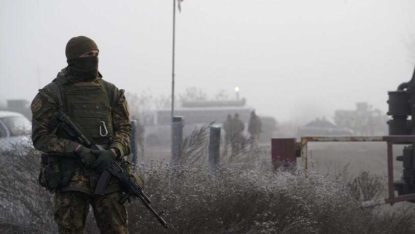 ARCHIV - Ein ukrainischer Soldat bewacht während eines Gefangenenaustausches. Foto: Evgeniy Maloletka/AP/dpa