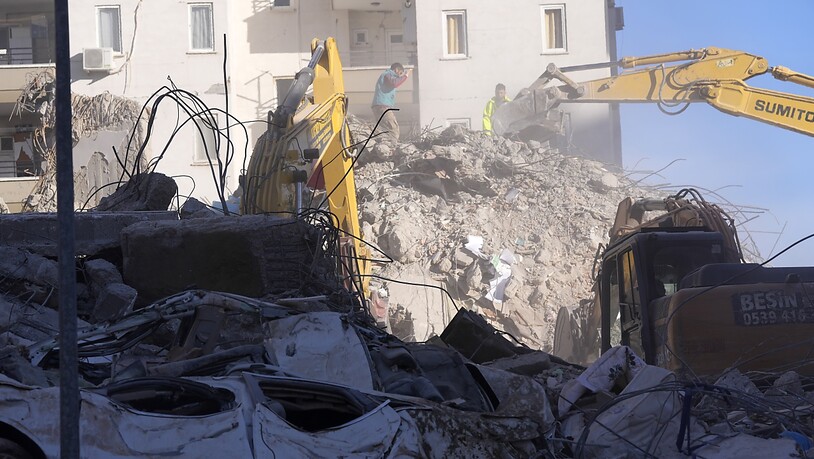 Mit schweren Maschinen wird bei eingestürzten Häusern in Adana Beton gebrochen, um verschüttete Personen aus den Trümmern zu bergen.