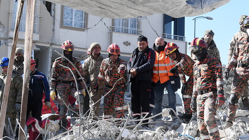 Einsatzkräfte suchen in den Trümmern nach Überlebenden. Foto: Hairul/BERNAMA/dpa