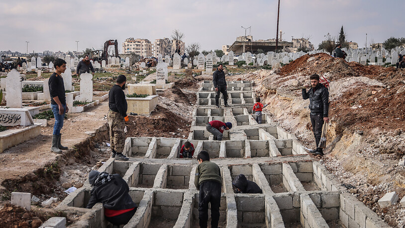 dpatopbilder - Syrer heben entlang der türkisch-syrischen Grenze Gräber für ihre Angehörigen aus, die bei dem verheerenden Erdbeben ums Leben gekommen sind. Foto: Anas Alkharboutli/dpa
