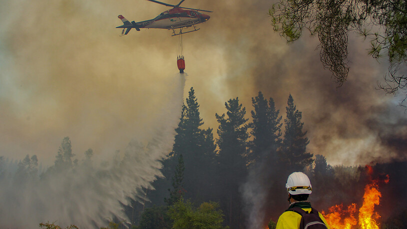 Ein Hubschrauber ist bei den Löscharbeiten während eines Waldbrandes in Chillan im Einsatz. Foto: Jose Humberto Campos/Agencia Uno/dpa