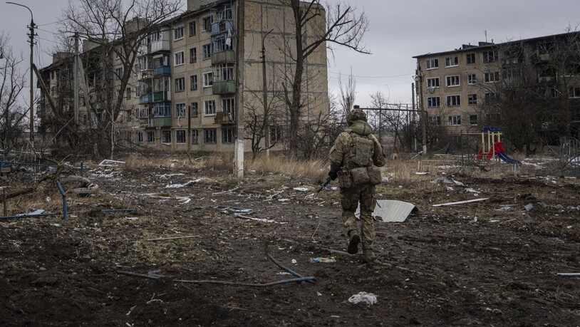 Ein ukrainischer Marinesoldat geht in Wuhledar an zerstörten Wohnblocks vorbei. Foto: Evgeniy Maloletka/AP/dpa
