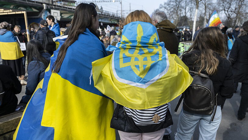 Personen tragen ukrainische Flaggen an der nationalen Friedenskundgebung in Bern. (KEYSTONE/Peter Schneider)