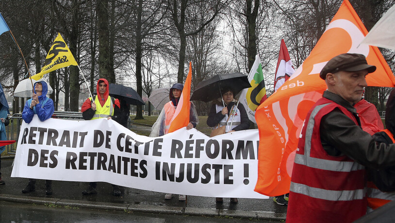 Demonstranten halten während eines Protests ein Banner mit der Aufschrift «Rücknahme dieser ungerechten Rentenreform!». Erneut haben Gewerkschaften zu Streiks und Protesten gegen die Pläne der Regierung aufgerufen. Die Reform sieht vor, das…