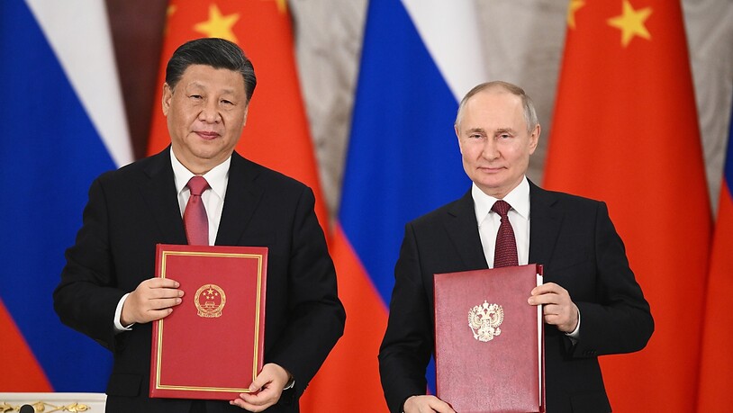Wladimir Putin (r), Präsident von Russland und Xi Jinping, Präsident von China, zeigen Mappen mit den Verträgen während einer Unterzeichnungszeremonie im Anschluss an ihre Gespräche im Großen Kremlpalast. Foto: Vladimir Astapkovich/Sputnik Kremlin Pool…
