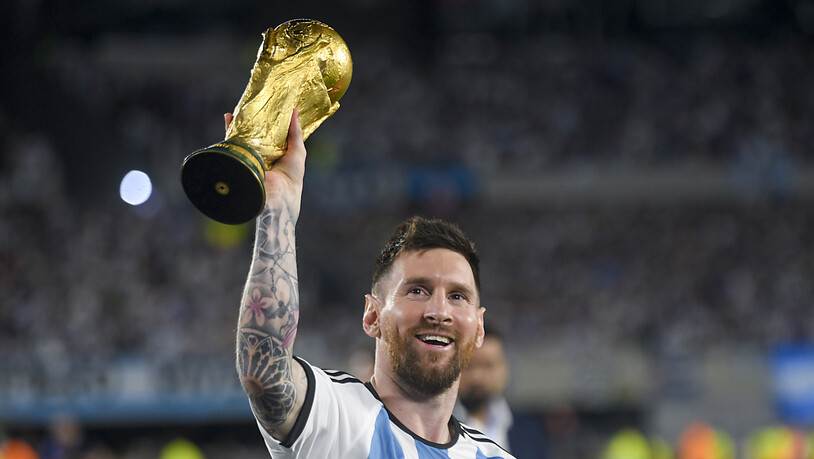 Lionel Messi zeigt dem Publikum in Buenos Aires nochmals den WM-Pokal.
