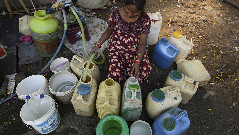ARCHIV - Eine Frau befüllt  in einem Slum am Weltwassertag Kanister mit Wasser aus einem öffentlichen Wasserhahn. Der Zugang zu sauberem Trinkwasser ist in vielen Gegenden der Welt keine Selbstverständlichkeit. Die Klimakrise verstärkt das Problem…