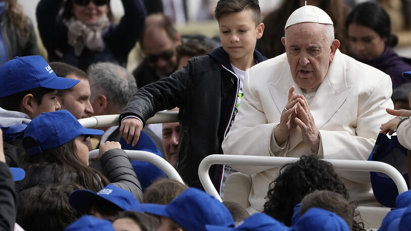 Papst Franziskus trifft Kinder am Ende seiner wöchentlichen Generalaudienz auf dem Petersplatz im Vatikan. Foto: Alessandra Tarantino/AP/dpa