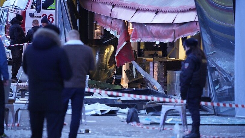 Russische Ermittler und Polizisten stehen am Tatort nach einer Explosion in einem Cafe. Ein russischer Kriegsberichterstatter ist am Sonntag bei einer Explosion in einem Cafe im Zentrum der russischen Ostseemetropole Sankt Petersburg ums Leben gekommen…
