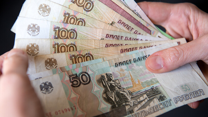 Ein Frau hält russische Rubel-Banknoten in den Händen. (Archivbild)