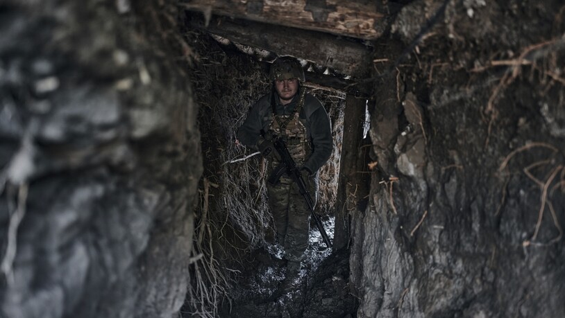 Ein ukrainischer Soldat steht in einem Graben an der Frontlinie einer Kleinstadt. Foto: Libkos/AP