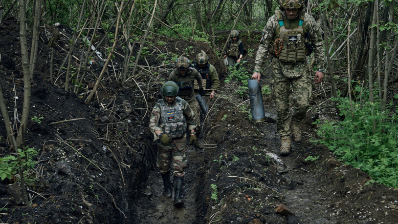 Ukrainische Soldaten gehen in einem Graben in der Nähe von Bachmut. In der Stadt finden Kämpfe gegen russische Truppen statt. Foto: Libkos/AP/dpa