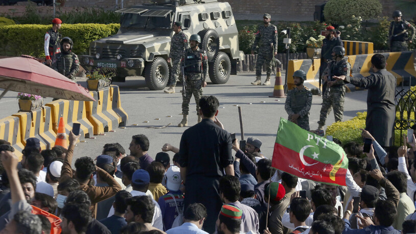 Paramilitärische Soldaten des Frontier Corps stehen Wache vor ihrem Hauptquartier, wo Anhänger des ehemaligen pakistanischen Premierministers Khan gegen die Verhaftung ihres Anführers protestieren. Foto: Muhammad Sajjad/AP/dpa