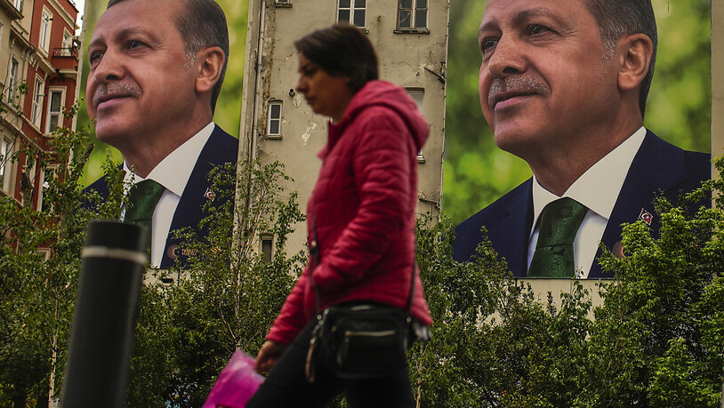 Eine Frau geht an Plakaten des türkischen Präsidenten und des Präsidentschaftskandidaten der Volksallianz, Erdogan, vorbei. Foto: Emrah Gurel/AP/dpa